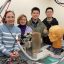 Standing beside their prototype of an ms-CBCT machine are, left to right, Professor Christy Inscoe, Materials Science Ph.D. candidate Negar Mehrabi, and first and second authors of the research article, respectively, Shuang Xu and Yuanming Hu.